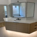 Modern floating vanity with premium bathroom renovation features, soft under-cabinet lighting, and contemporary mirrors in a remodeled Plano, TX bathroom.