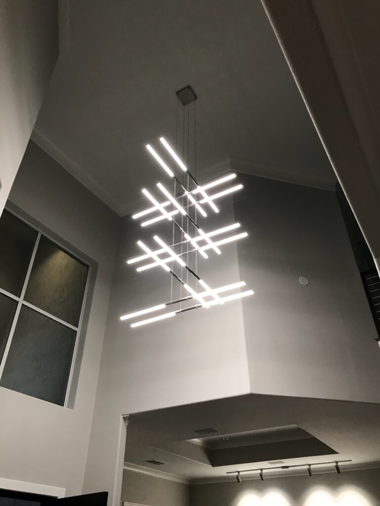 Bright contemporary interior with modern chandelier and energy-efficient window in a high-ceiling Plano home
